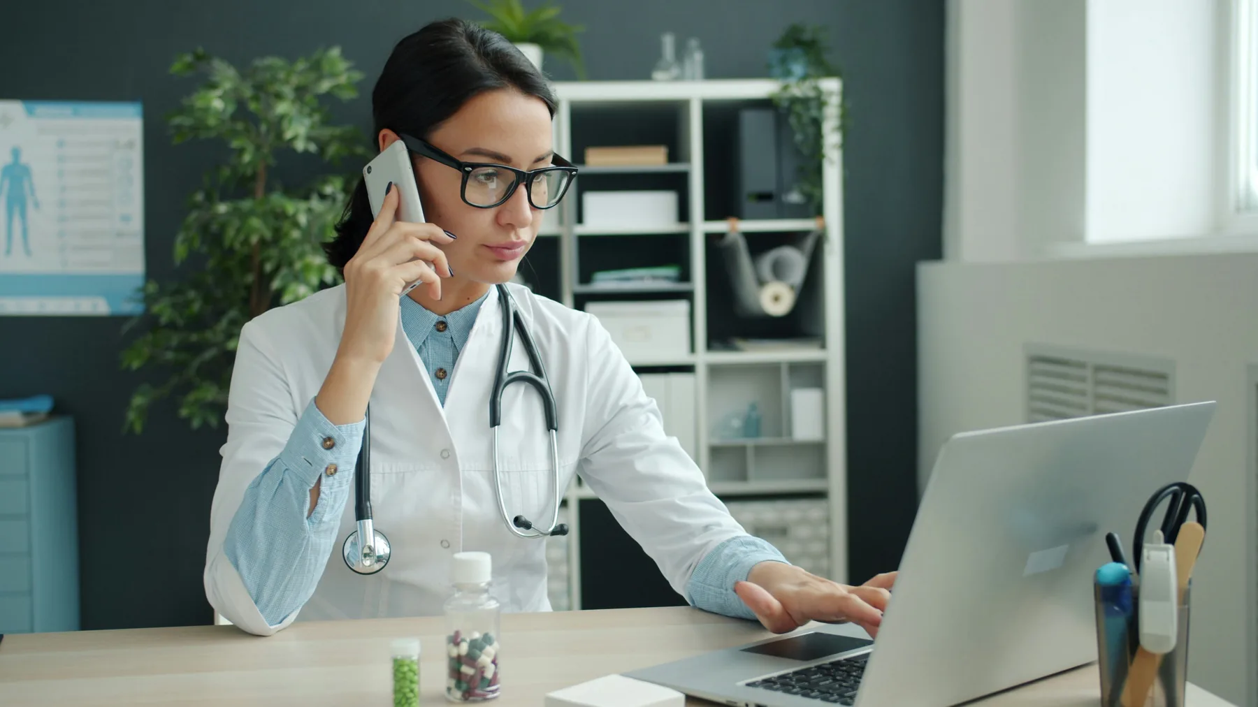 Healthcare professional handling a call and computer work
